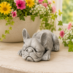Gray French bulldog figurine on a wooden surface with flowers in the background